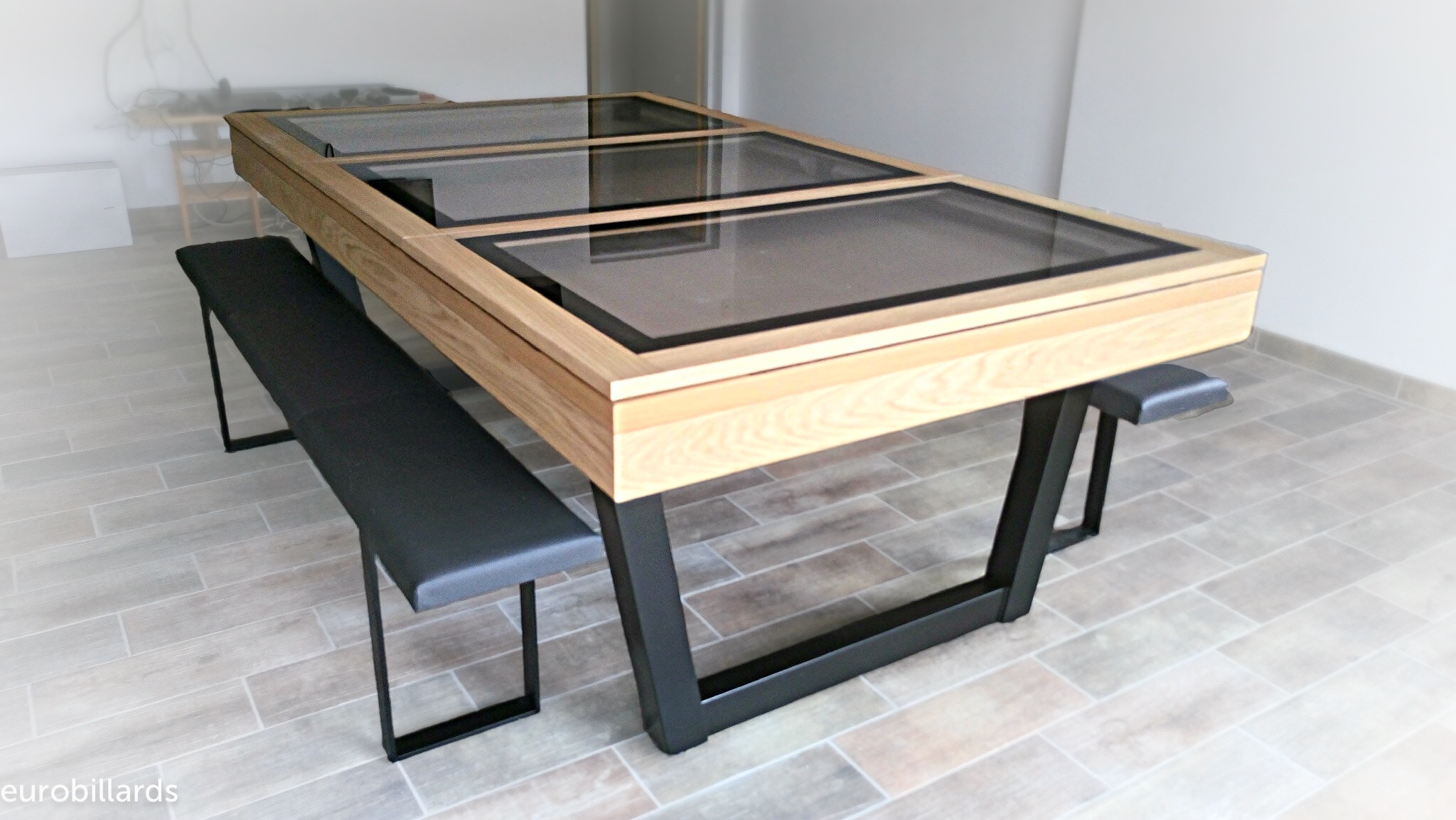 Ce billard HARMONY-V transformé en une table design de bois et de verre par l'adjonction d'un plateau BV qui montre le tissu taupe du jeu américain. Les lignes des pieds répondent au pieds des 2 bancs Fabrik à l'assise en simili cuir noir et aux liserés tous noirs qui séparent le verre du bois est un bon achat de billard table malin pour ce client qui ne le laissera suremant jamais trainer dans un coin. Merci